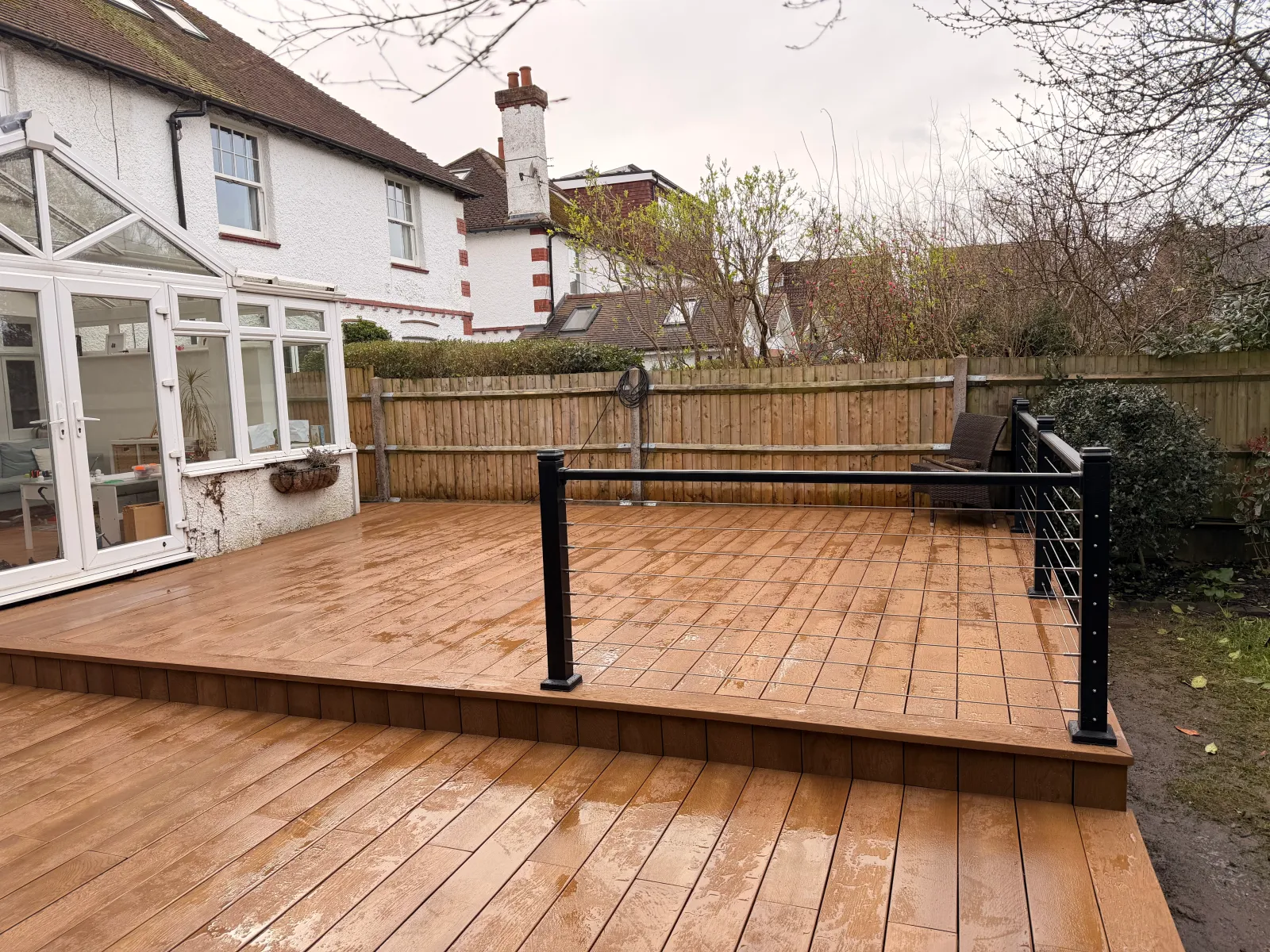 Low-maintenance composite decking boards laid across a landscaped Surrey garden