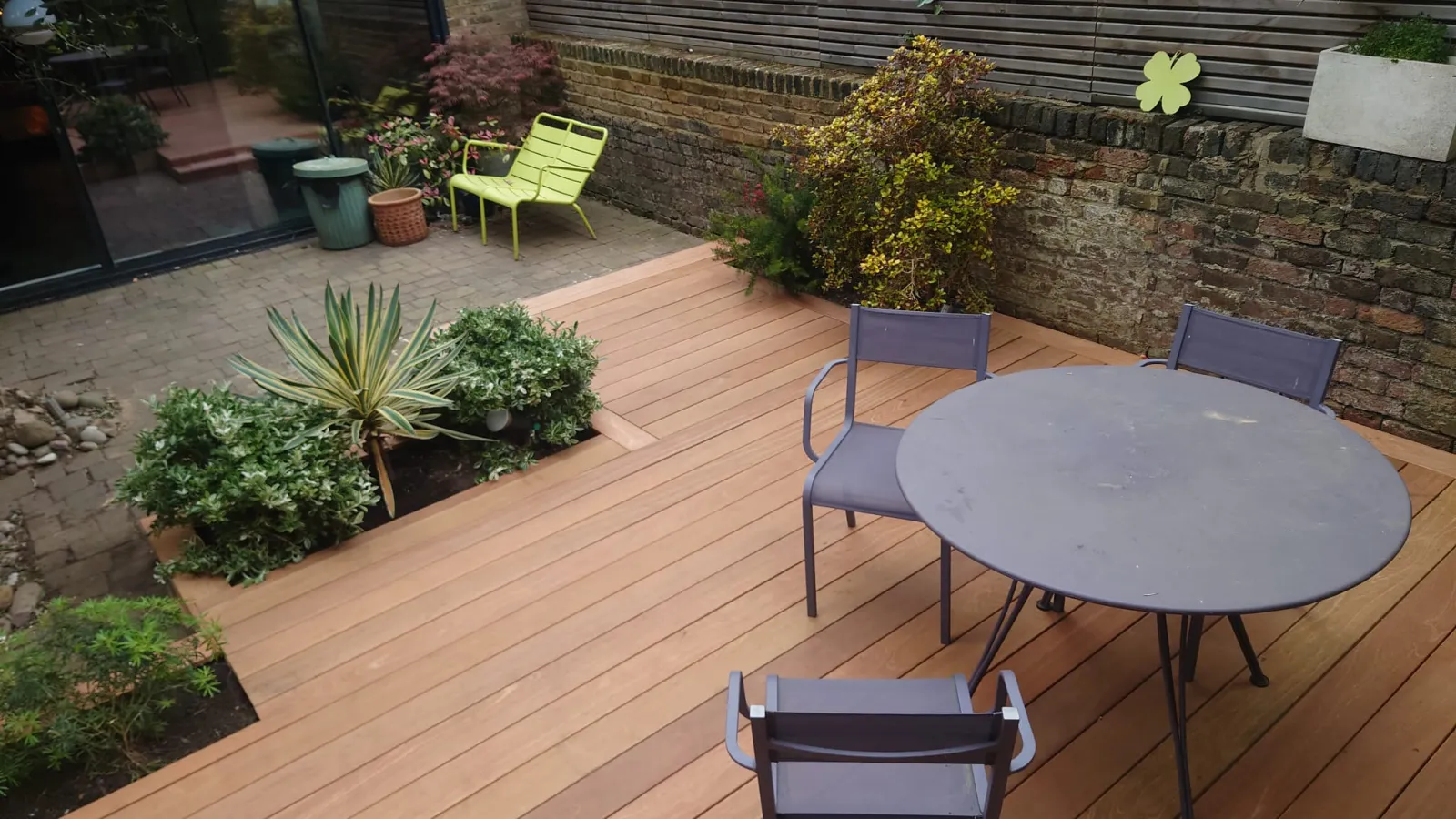 Hardwood decking with a sophisticated finish surrounding a garden patio